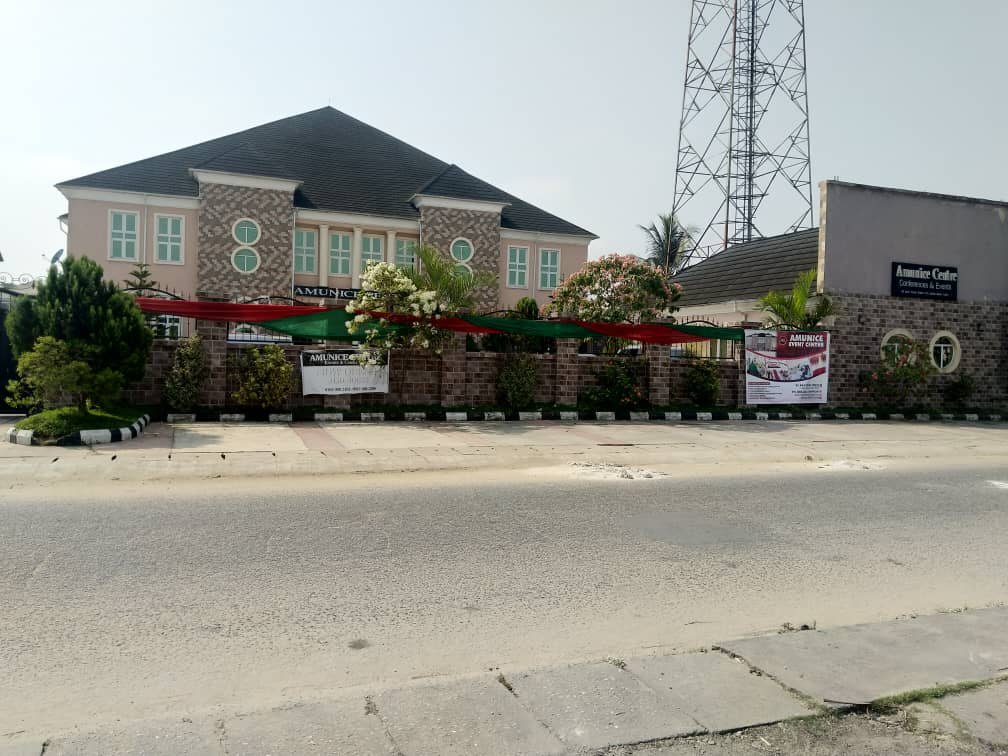Amunice Event Centre building seen from the road, with banners on the fence