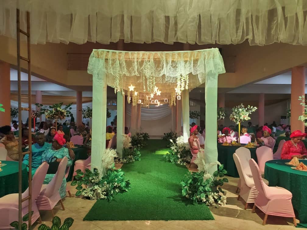 Green aisle under a white canopy